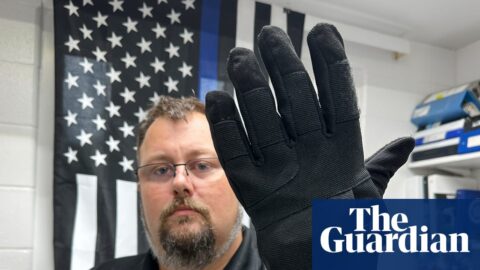 a man in uniform wears a bulky black glove