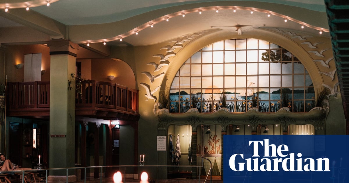 Swimmers in Centralbadet's ornate Art Nouveau pool, lit candles and stained-glass window